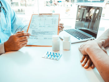 Midsection of man using laptop on table