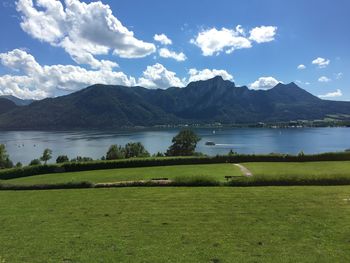 Scenic view of lake by mountains against sky