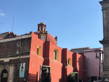 Low angle view of buildings against clear blue sky