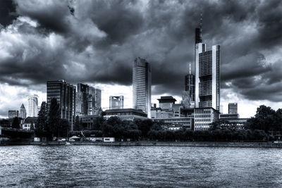 Low angle view of skyscrapers against cloudy sky