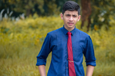 Portrait of young man standing on field