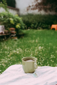 Coffee cup on table in field