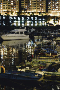 Boats moored in river by buildings in city