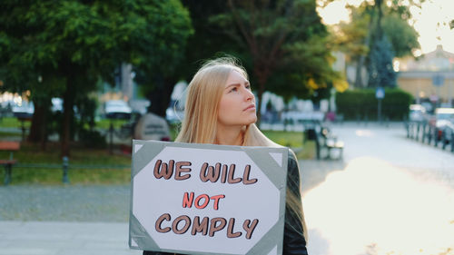 Portrait of woman with text standing outdoors