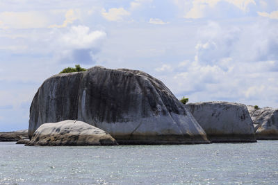 Rock formations by sea against sky