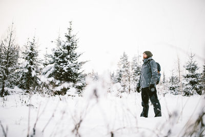 Full length of woman standing on snow covered field