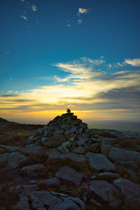 Scenic view of rock against sky during sunset