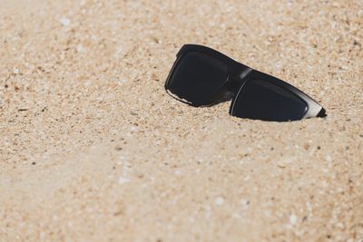 High angle view of sunglasses on sand