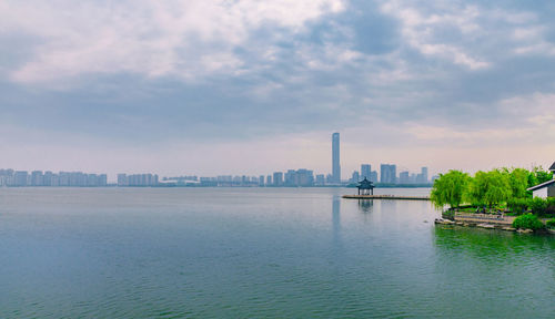 View of city buildings against cloudy sky