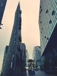 Low angle view of buildings against clear sky at sunset