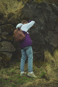 Rear view of man standing on rock in forest