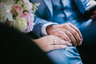 Midsection of bride holding bouquet