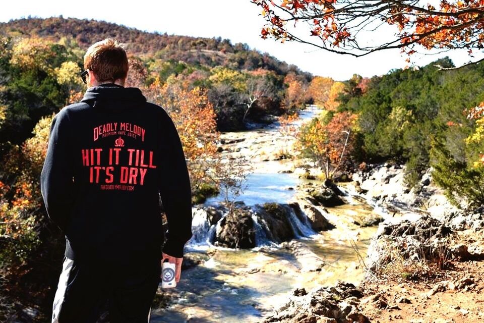 lifestyles, water, leisure activity, men, rear view, standing, casual clothing, tranquility, nature, scenics, tranquil scene, rock - object, tree, beauty in nature, vacations, full length, river, person