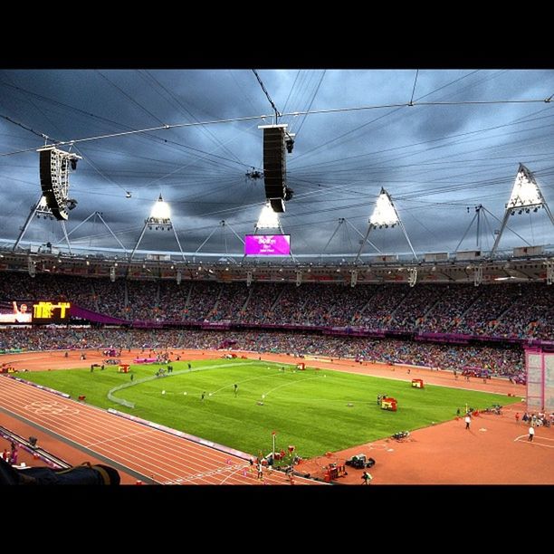built structure, power line, architecture, large group of people, building exterior, cable, electricity, sky, fuel and power generation, power supply, auto post production filter, lighting equipment, stadium, hanging, day, transfer print, connection, electricity pylon, outdoors, technology