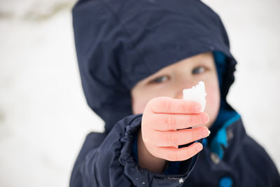 Close-up of boy holding snow