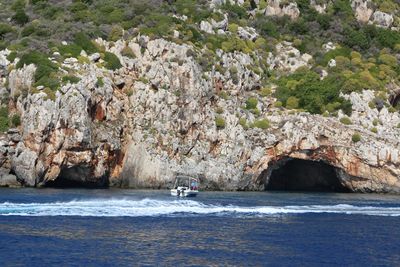 People on rock by sea