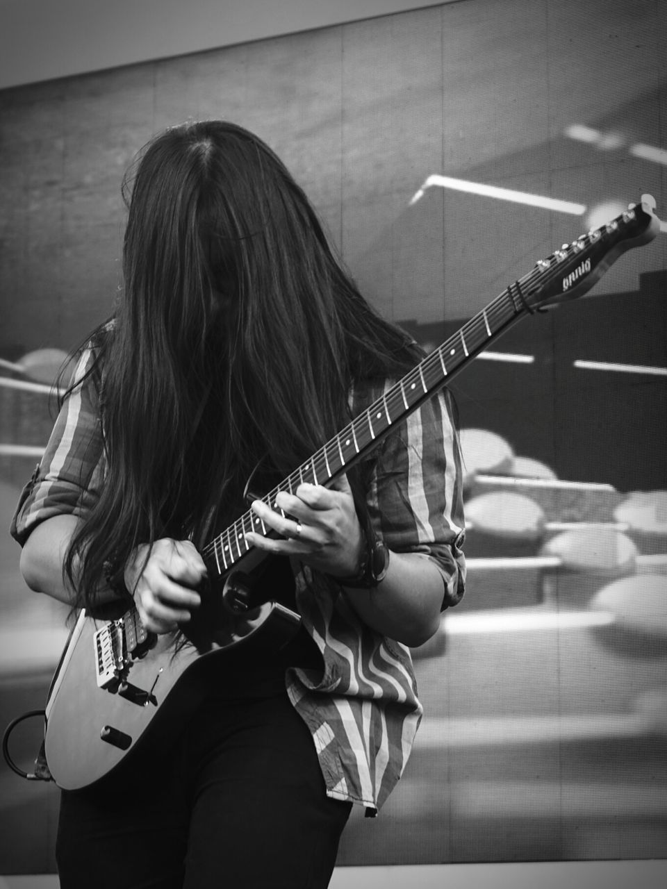 musical instrument, playing, real people, music, one person, skill, arts culture and entertainment, musician, long hair, lifestyles, performance, indoors, leisure activity, standing, occupation, day, young adult, electric guitar, guitar, people