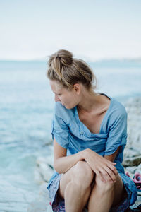 Young women sitting on rock at beach