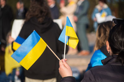 Midsection of woman holding flags