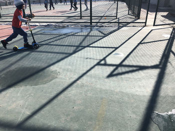 Low section of man with shadow on footpath
