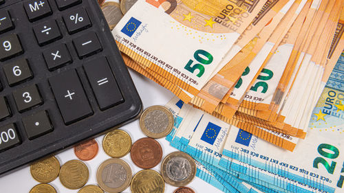 Close-up of euro currency coins, banknotes and calculator, finance planning concept