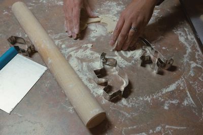 Cropped hand of woman making cookies with dough at table