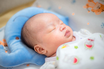 Close-up of cute baby boy sleeping on bed at home