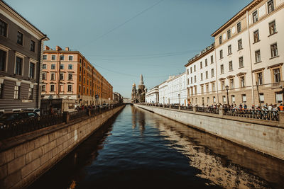 Canal amidst buildings against sky in city