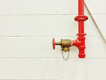 Red pipe against white wall