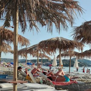 People at beach against sky