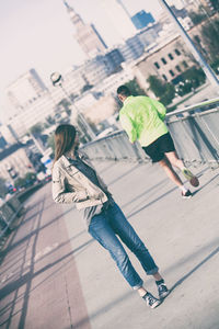 Woman looking at man jogging on footpath