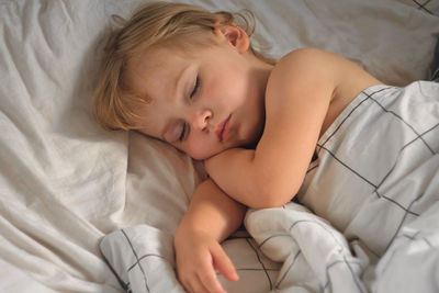 Cute baby sleeping on bed at home