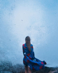 Woman with umbrella against blue sky