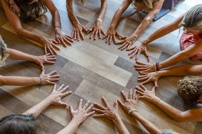 Group of friends practicing meditation with hands on floor