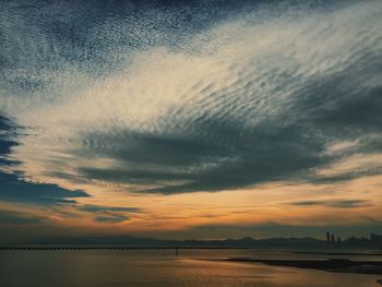 Scenic view of beach against dramatic sky