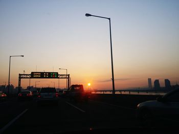 Traffic on road at sunset