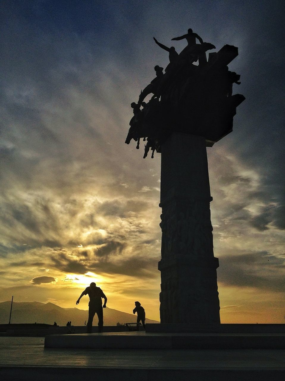 sunset, sky, silhouette, cloud - sky, men, orange color, built structure, architecture, cloudy, lifestyles, low angle view, cloud, dramatic sky, standing, dusk, leisure activity, person, outdoors