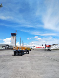 Airplane on airport runway against sky