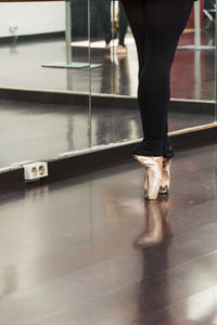 Low section of ballet dancer practicing on floor