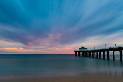 Pier over sea against sky during sunset