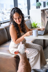 Portrait of young woman sitting on sofa at home