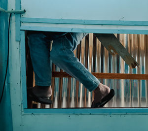 Low section of woman standing on railing