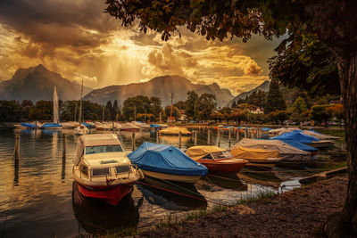 Boats in sea at sunset