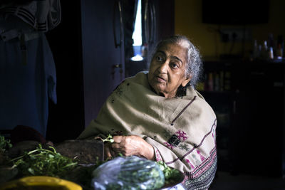 Senior woman sitting on chair at home