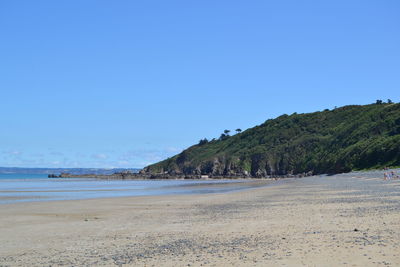 Scenic view of beach against clear blue sky