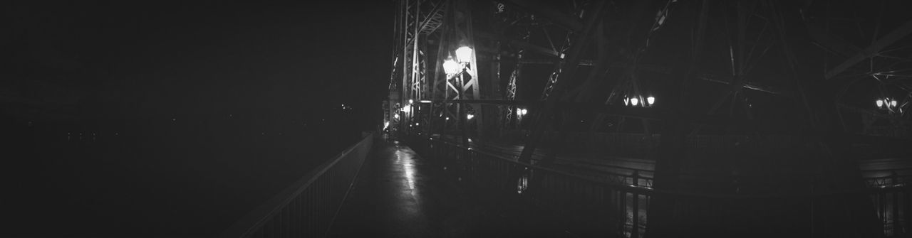 illuminated, night, built structure, the way forward, architecture, transportation, diminishing perspective, connection, bridge - man made structure, vanishing point, no people, dark, railing, indoors, long, empty, lighting equipment, reflection, street light