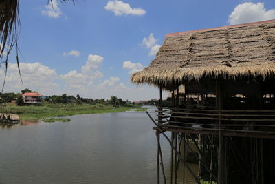 Scenic view of lake and houses against sky