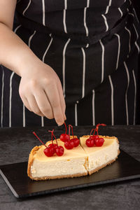 The chef decorates a classic cheesecake with cherry berries