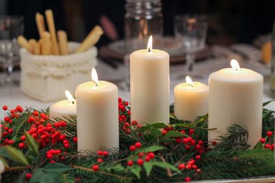 Close-up of illuminated candles with plants on table