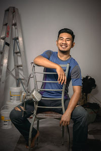 Portrait of young man sitting on chair